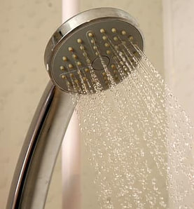 Chrome shower head spraying water